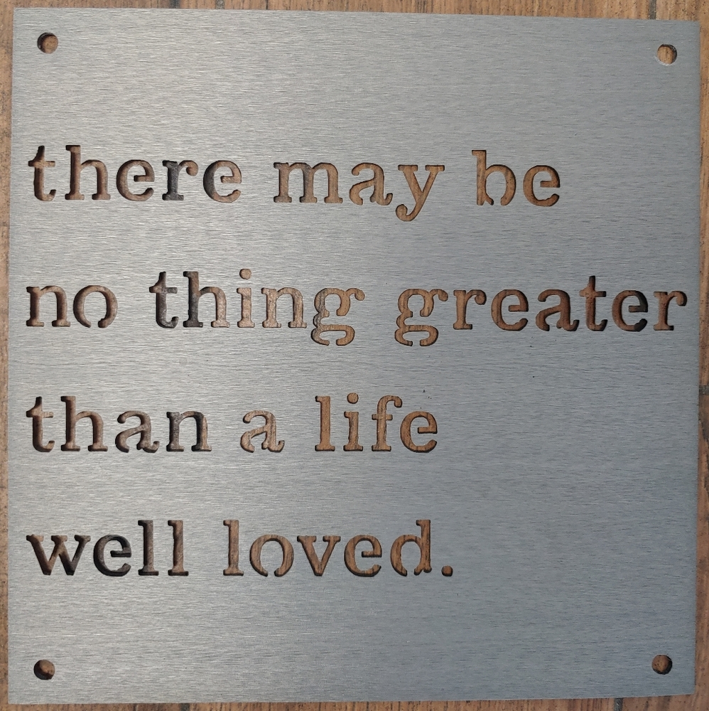 Metal sign with cutout wording.